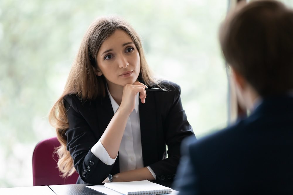 A woman listening compassionately to another person.