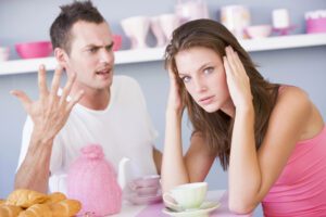 Agressive man and overwhelmed woman arguing.