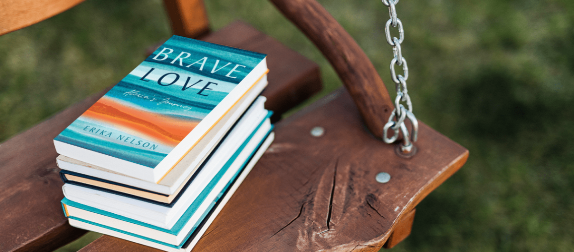 Stack of books on a wooden swing with the book Brave Love: Alexia's Journey on top of the stack.