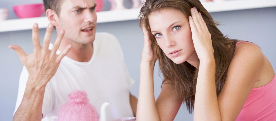 Agressive man and overwhelmed woman arguing.